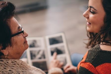 Young woman looking at a photo-album with her grandmother